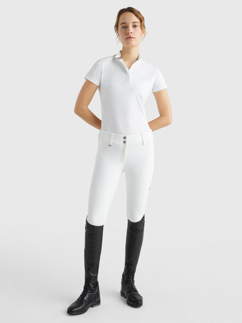 Tommy Hilfiger Equestrian® »Damen Turniershirt mit Strass Weiß, mit Stehkragen und verdeckter Knopfleiste. Sichtbarer Strassknopf am Kragen und TH-Strassapplikation auf der linken Brust. Hergestellt aus einem schnell trocknenden, desodorierenden Stoff Artikelnummer th07wsss301-001 erhältlich bei www.Hotti24.de