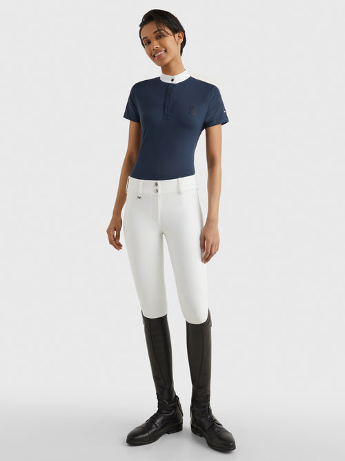 Tommy Hilfiger Equestrian® »Damen Turniershirt mit Strass Blau, mit Stehkragen und verdeckter Knopfleiste. Sichtbarer Strassknopf am Kragen und TH-Strassapplikation auf der linken Brust. Hergestellt aus einem schnell trocknenden, desodorierenden Stoff Artikelnummer th07wsss301-004 erhältlich bei www.Hotti24.de