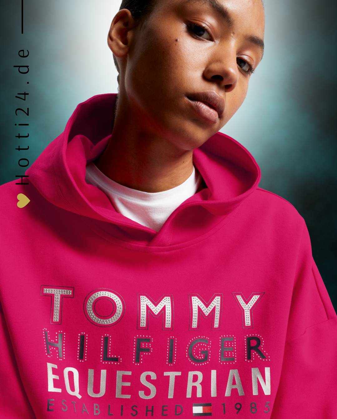 Damen-Hoodie von Tommy Hilfiger mit der Bezeichnung "Hoodie Paris TH08WHOO441-040" in der Farbe Pink. Dieser Hoodie ist auf der Webseite www.hotti24.de erhältlich. Er wurde speziell für Damen entworfen, um sowohl Stil als auch Komfort zu bieten.  Zusätzlich sind in der Datei Bilder des Hoodies aus verschiedenen Blickwinkeln enthalten: von vorne, von der Seite und von hinten. 